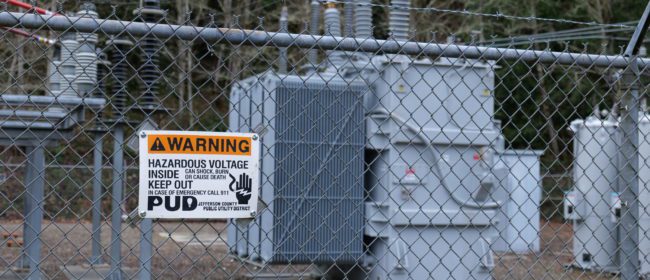 Close up of a substation and a voltage warning sign