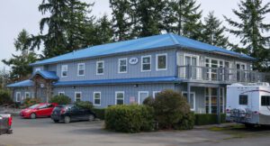 Images of building with a blue roof and blue-gray siding. Future location of PUD administrative services.