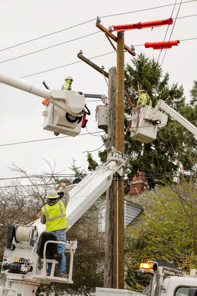 Line crew work to transfer three-phase power from an old danger pole to a new pole in Port Townsend.