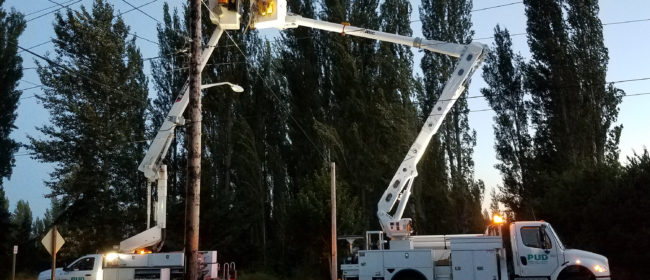 Two PUD trucks lifting staff up to work on power lines